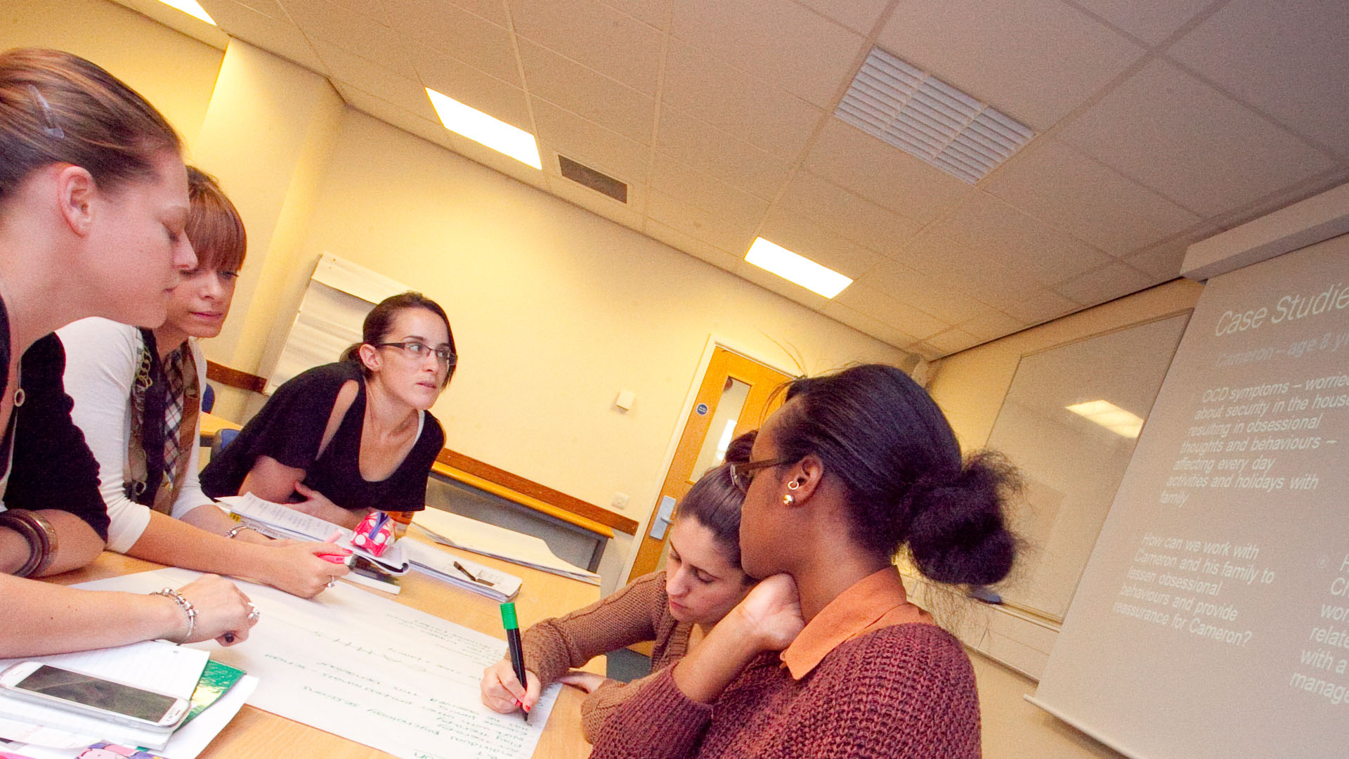 A group of students and a teacher sat around a table