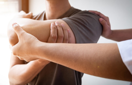 A physiotherapist treating an injured rotator cuff with a stretching exercise