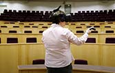 lecturer wearing a VR headset on in a lecture theatre