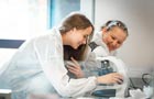 Two female pharmacologists one working with a microscope