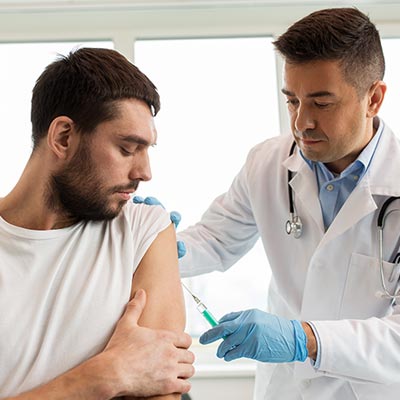 Doctor administering a vaccine to a male patient