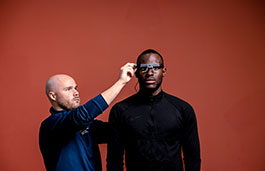 Male adjusting a pair of glasses on another persons head