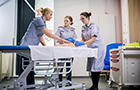 Three nurses in training on a fake baby