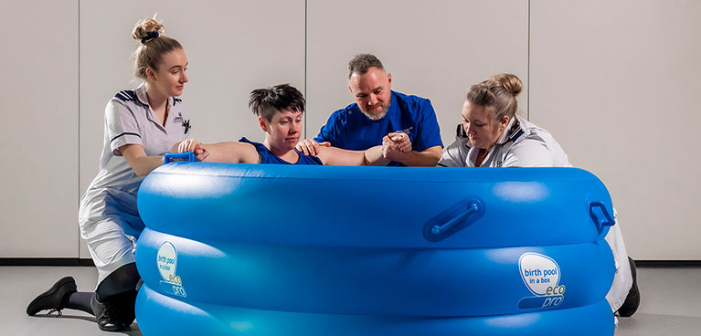 Midwifery Suite with patient in birthing pool and nursing staff around a birthing pool