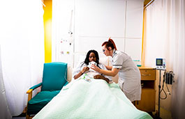 Nursing staff providing updates to a patient who is lying on a bed