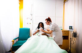 Nursing student taking care of a patient in bed