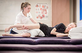 A Physiotherapist working on a patient lying on the therapy couch receiving treatment