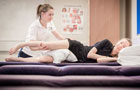 A Physiotherapist working on a patient laying on the therapy couch