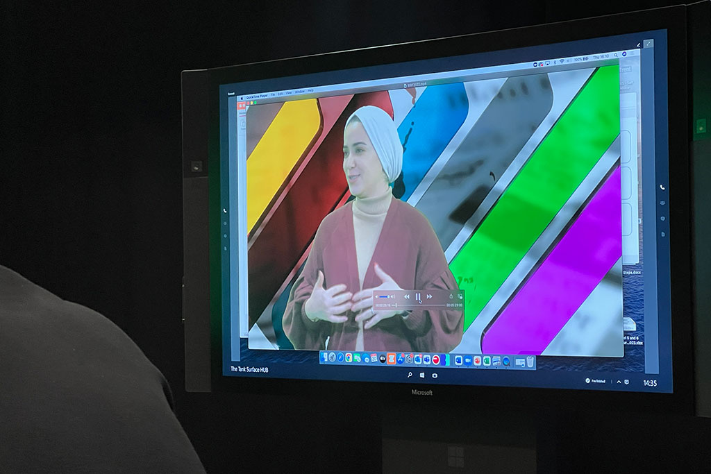 Student seen on TV screen with colourful background
