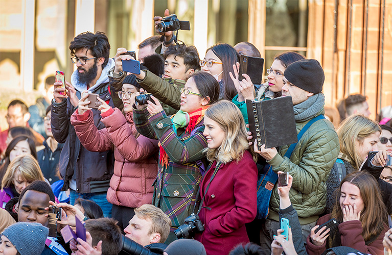 Close up of the crowd with people holding cameras and phones