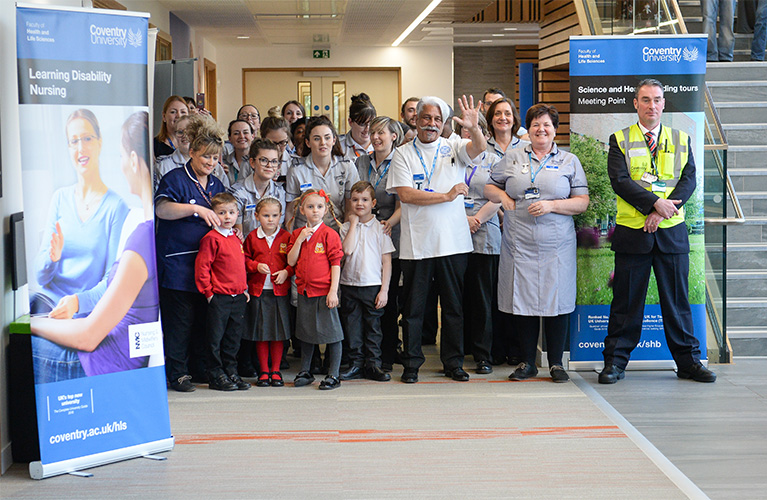 Staff, students and a group of primary school children at the official opening of the Health and Life Sciences building waiting to meet the Duke and Duchess of Cambridge