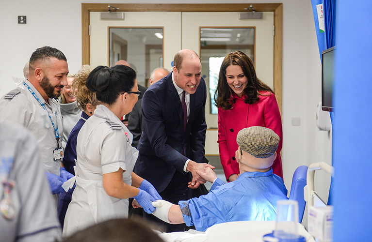 The Duke and Duchess of Cambridge talking and shaking hands with a mock patient