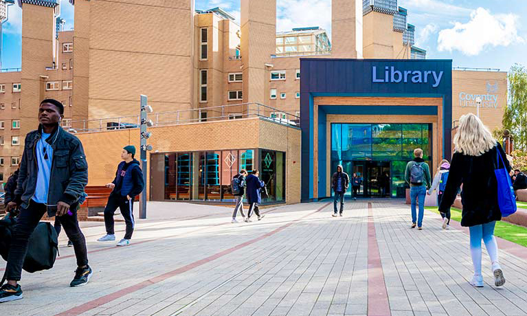 The Library building from the outside with people walking towards and away