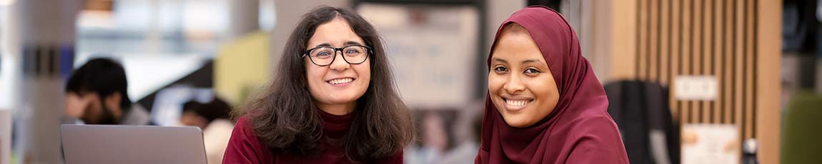 Two postgraduate students smiling