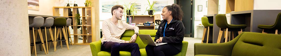 Student and success coach chatting on a lime green sofa.