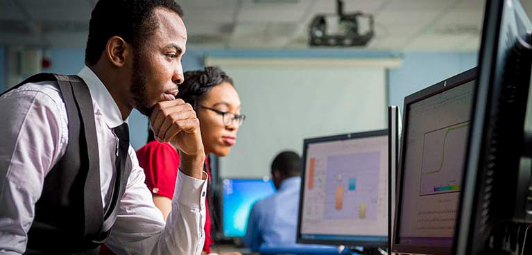 Students looking at monitors on desks