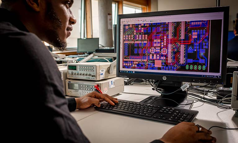 UG male student looking at a monitor showing a complex graph