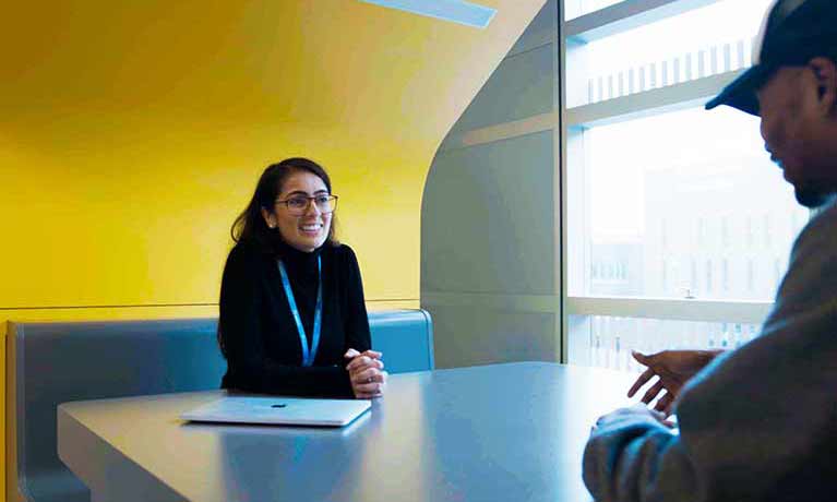 success coach and student chatting in a booth