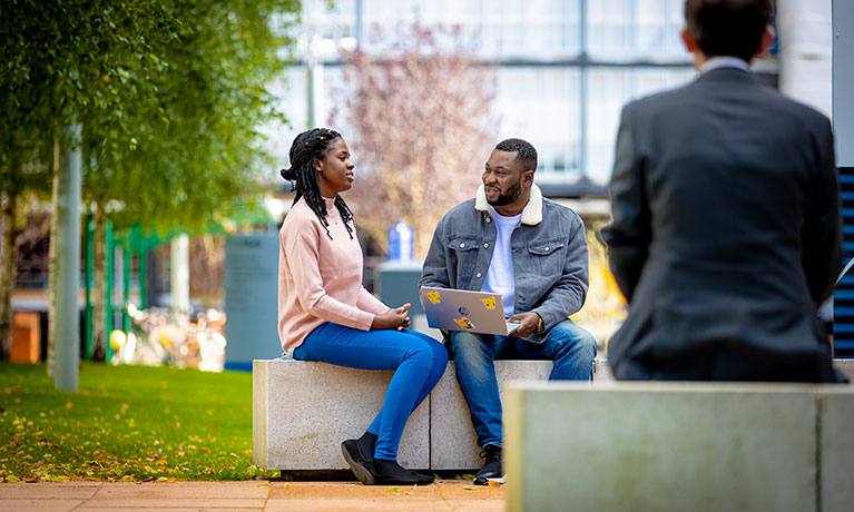 Two students sitting outside the campus 