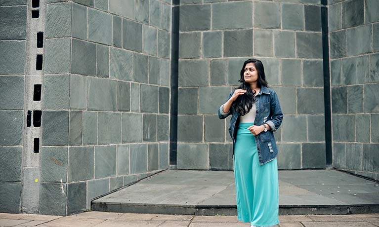 Naeema Ghulam Hussian student standing in an concrete building Naeema Ghulam Hussian