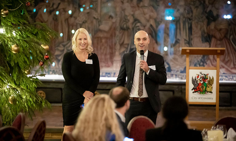 People speaking at an event on stage