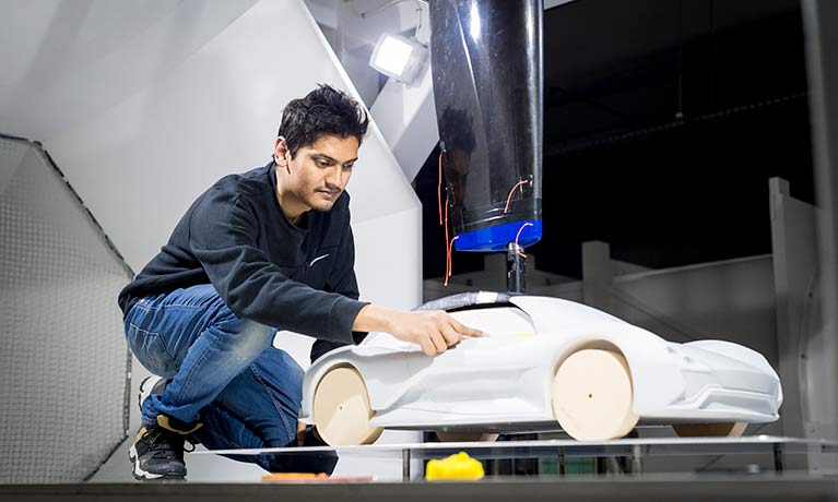 student working on a model car