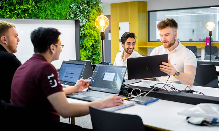 4 male students studying around a table 