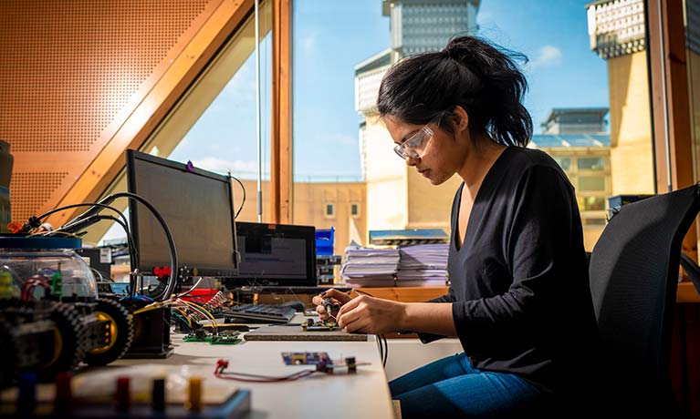 Female student working on circuit boards