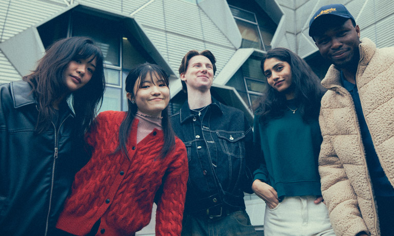 A group of students smiling for the camera outside the Engineering building
