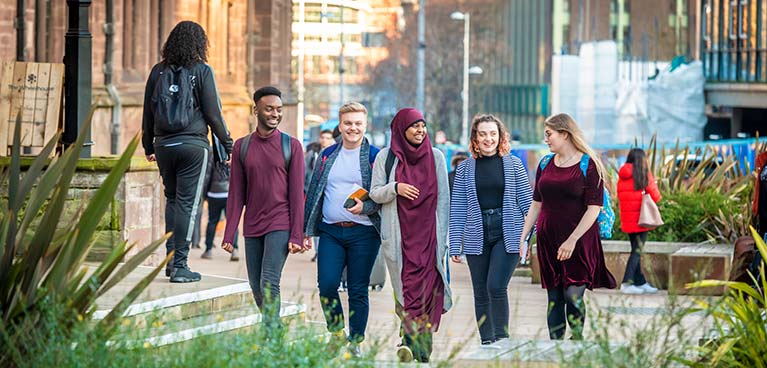 Group of students walking through the city smiling