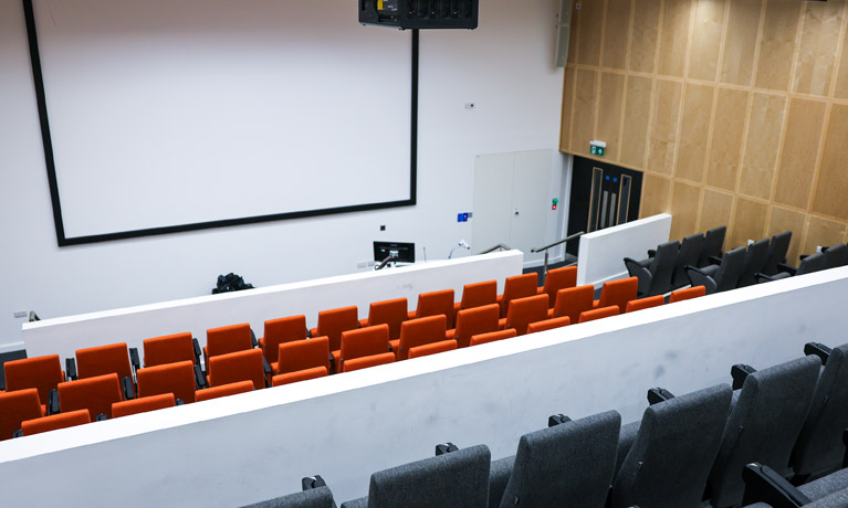 Lecture theatre with a large screen and tiered seating
