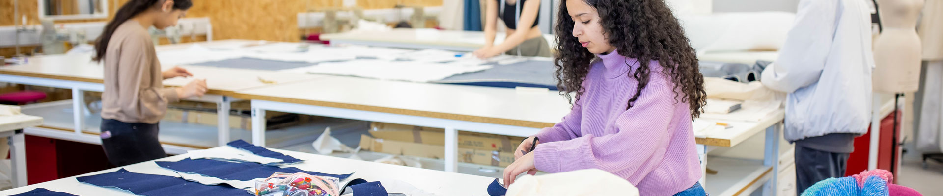 Fashion students cutting and measuring material.