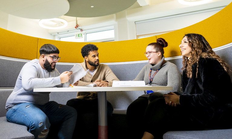 Four students sat around a table in an open study area booth at CU Coventry.