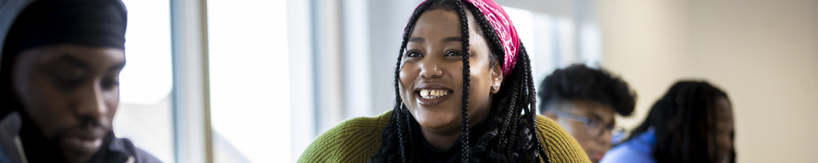 Head and shoulder shot of a smiling student sitting in a breakout area Coventry University London