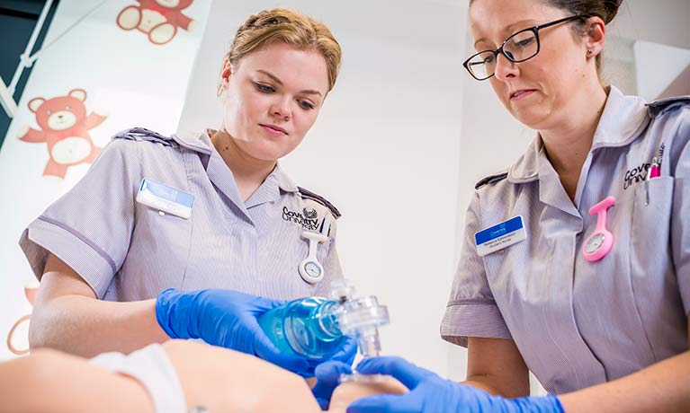 Two nurses tending to a pretend baby 