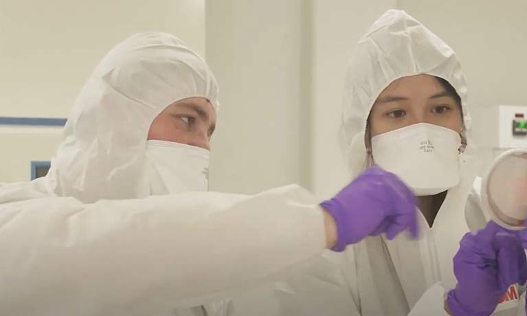 students in white protective suits and gloves