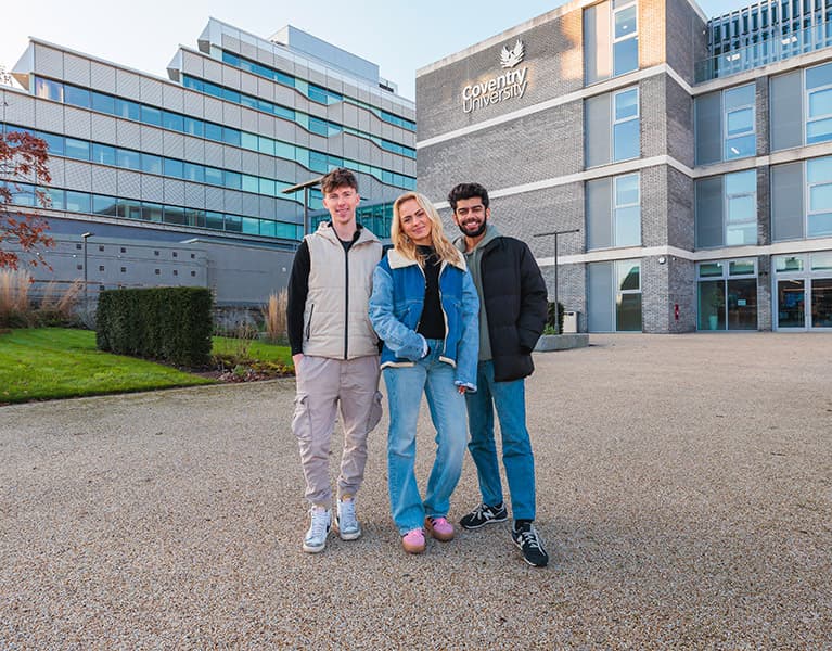 Three students stood outside on the campus