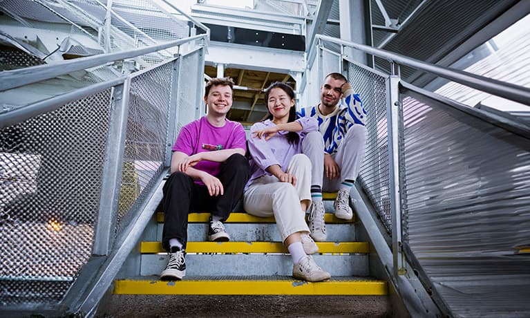 Students sitting on the steps of a building
