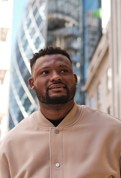 BAME male student with London buildings in the background