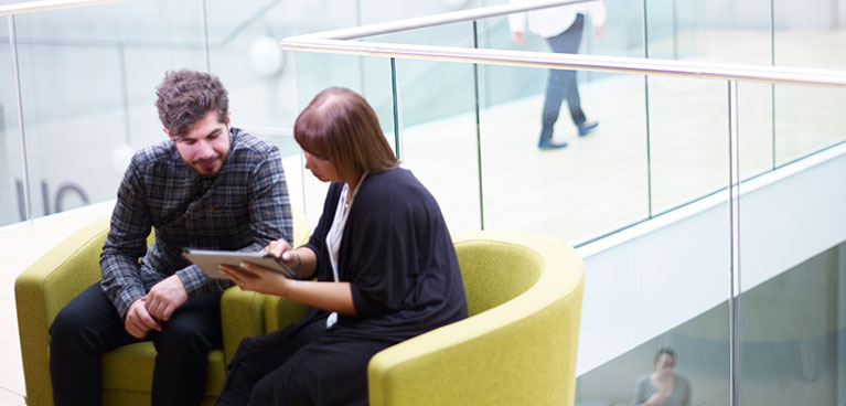 Two people chatting closely on a sofa