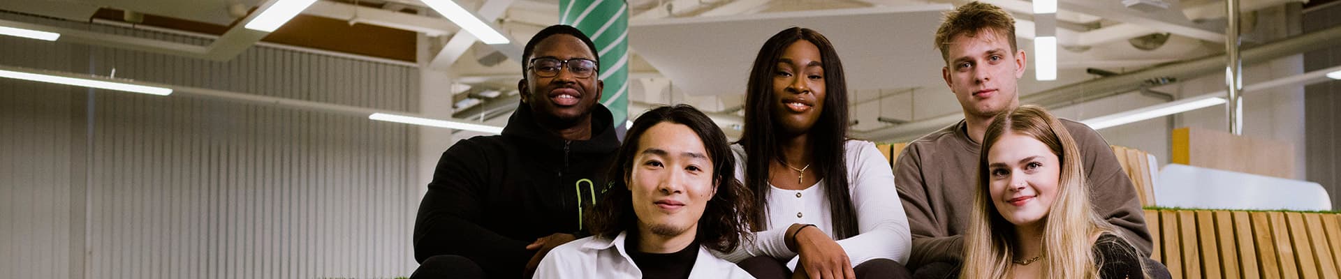 Group of students sitting on a wooden bench