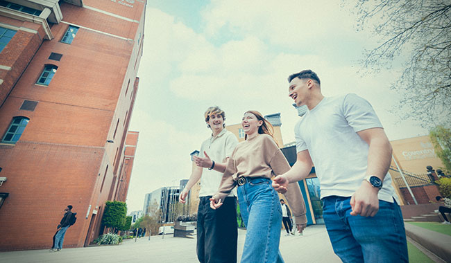 Three students walking on campus 