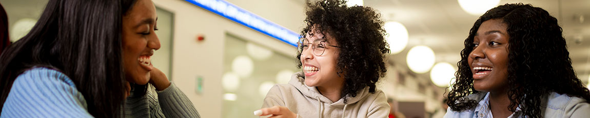 Three students chatting and laughing together.