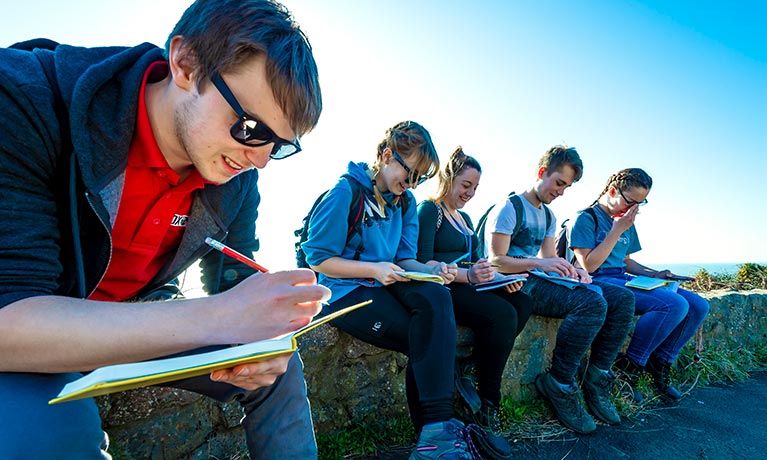 Students working together, sitting outside