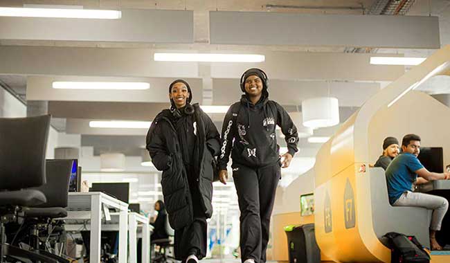 Two students walking through the Student Hub