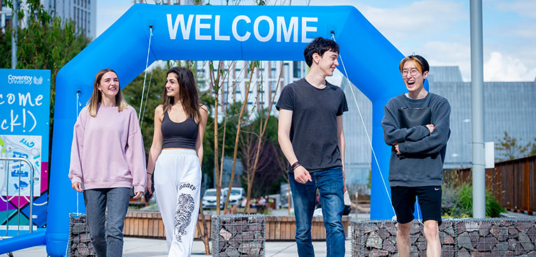 Two female and two male students walking and laughing in starley gardens