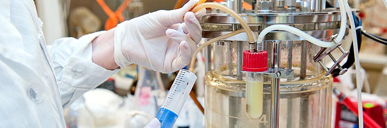 Person wearing lab coat conducting an experiment.