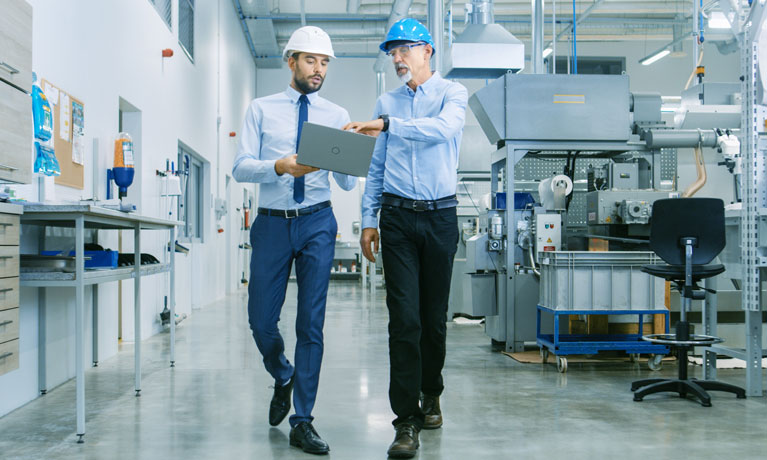 Two business men walking through a workshop