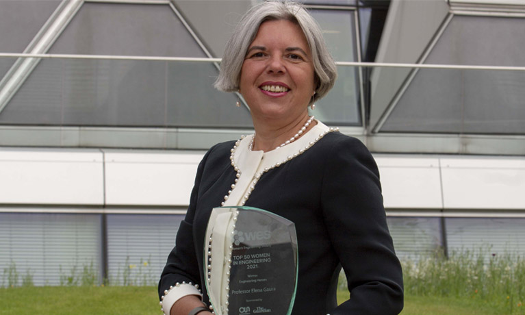 Professor Elena Gaura holding Women in Engineering 2021 award outside Coventry University EEC Building