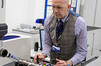 Lecturer using a piece of equipment in a lab